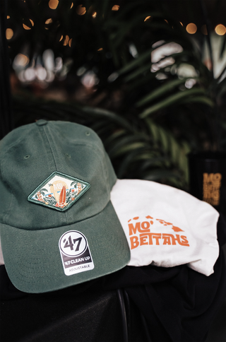 The green Mo' Bettahs Patch hat with graphic and white t-shirt with Mo' Bettahs island logo in orange.