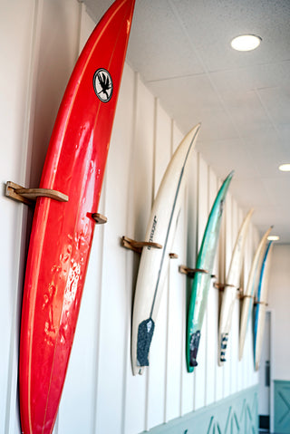Six surf boards on display, lining the wall.