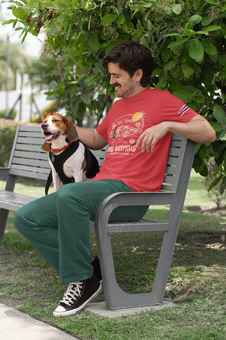 Man sitting on bench with a beagle, wearing Mo' Bettahs Teri Sauce red T-shirt, showing front Teri Sauce graphic and Hawaii state flag graphic on left sleeve.